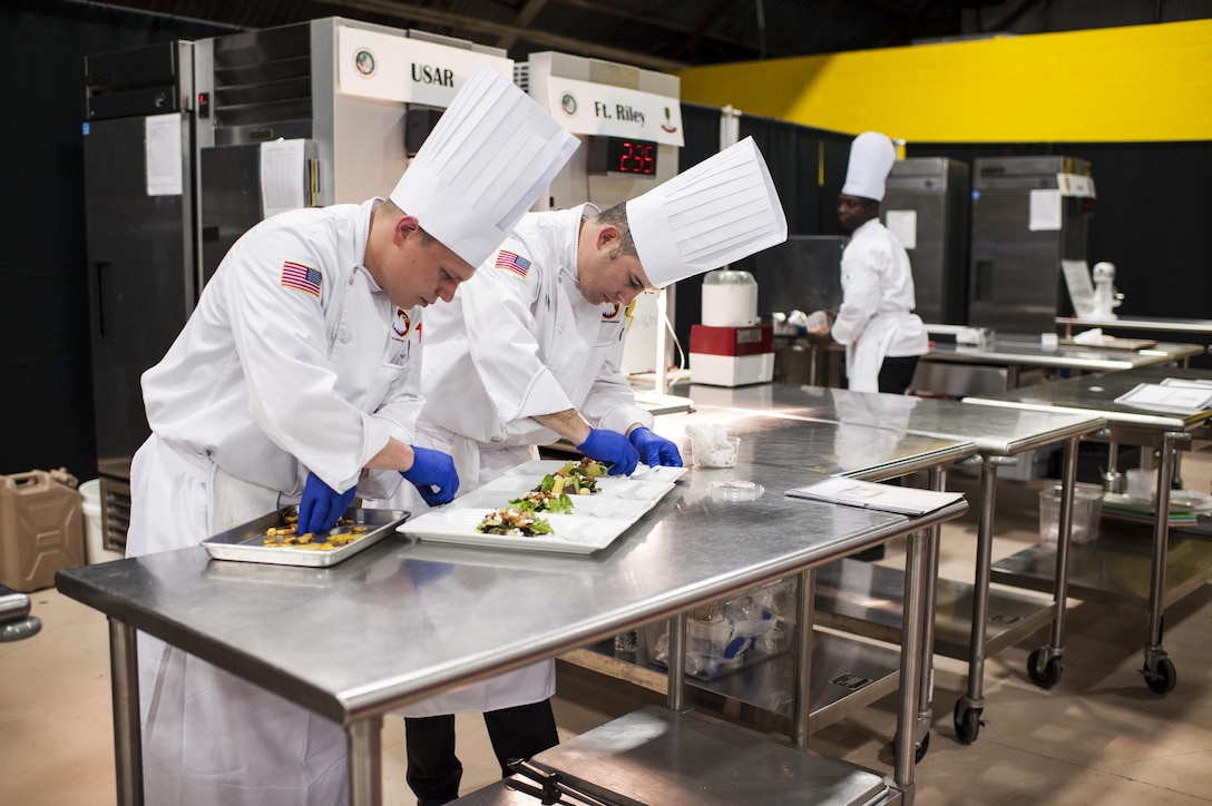 U.S. Army Reserve Culinary Arts Team members, Staff Sgt. Joseph Parker, left, with the 451st Quartermaster Company, 143rd Sustainment Command (Expeditionary), and Sgt. Joshua Barnhill, with the 377th Theater Sustainment Command, plate up their first course during the Nutritional Hot Food Challenge category at the 41st Annual Military Culinary Arts Competitive Training Event, March 8, 2016, at Fort Lee, Va. Parker and Barnhill earned a silver in the category with their roasted beet salad, pan-seared trout, and eggless, milkless spice cake, all coming in at under 850 calories. (U.S. Army photo by Timothy L. Hale) (Released)