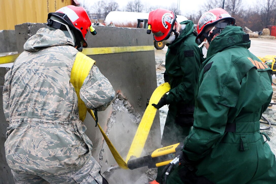 Virginia National Guardsmen use a high-powered cutting tool to cut through a concrete block as they search for mock survivors during the Sovereign Guardian 2016 exercise with members of the District of Columbia Fire and Emergency Medical Service Department at the Washington Fire and EMS Training Academy in Wash., D.C., Feb. 24, 2016. Virginia National Guard photo by Alfred Puryear