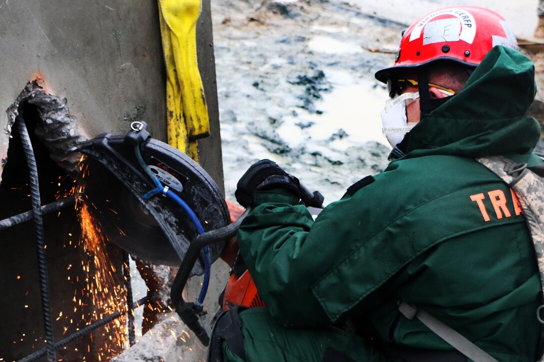 A Virginia National Guardsman use a high-powered cutting tool to cut through a concrete block while searching for mock survivors during the Sovereign Guardian 2016 exercise at the Washington Fire and EMS Training Academy in Wash., D.C., Feb. 24, 2016. Virginia National Guard photo by Alfred Puryear