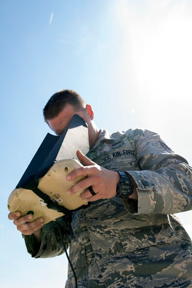U.S. Air Force Senior Airman Jeremy Cawlrow, 823d Base Defense Squadron RQ-11 B Raven small unmanned aircraft system operator, looks inside a vehicle operator hand controller during a mission capabilities demonstration, March 3, 2016, at Moody Air Force Base, Ga. The 820th Base Defense Group utilizes Falcon View data and the VO hand controller to navigate Ravens during real-world operations to conduct its intelligence, surveillance and reconnaissance mission. (U.S. Air Force photo by Airman 1st Class Greg Nash/Released) 
