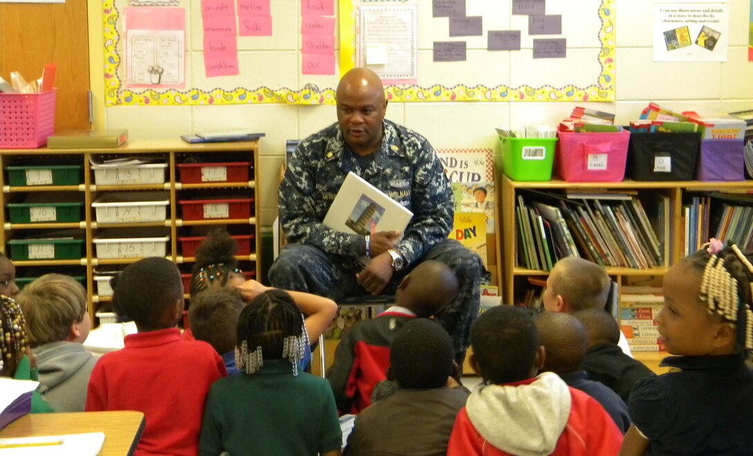 Lt. Cmdr. Donald Mitchell, senior nurse executive, Naval Branch Health Clinic-Albany, located at Marine Corps Logistics Base Albany, reads to a group of students at Alice Coachman Elementary School, Albany, Ga., during the Read Across America activities. The recent event is held nationally to commemorate the birthday of author/illustrator, Theodor Seuss Geisel, better known as Dr. Seuss. 