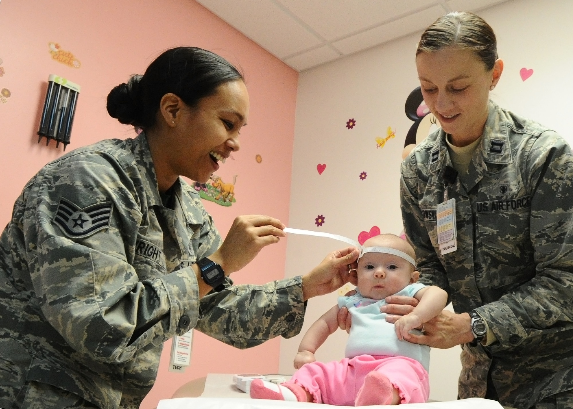Staff Sgt. Lisette Wright, 325th Medical Operations Squadron aerospace medical technician and Capt. Shauna Sokolowski, 325th MDOS pediatric registered nurse, measures the circumference of a toddler's head March 4 at the 325th Medical Group. Measurements are taken during well visits to track the development of children. (U.S. Air Force photo by Senior Airman Ty-Rico Lea)