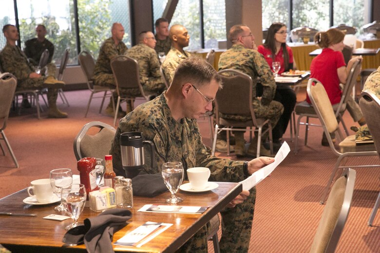 Lt. Cmdr. Michael Slaughter, chaplain, Combat Logistics Battalion 7, looks over documents regarding the Navy-Marine Corps Relief Society during the Active Duty Fund Drive Kickoff Breakfast at the Frontline Restaurant, March 7, 2016. (Official Marine Corps photo by Cpl. Thomas Mudd/Released)