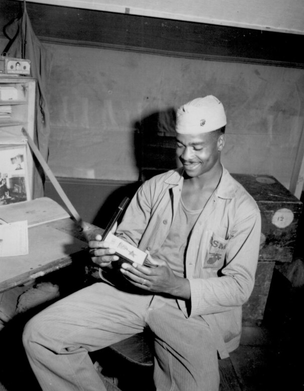 Pfc. Luther Woodward, a member of the 4th Ammunition Company, admires the Bronze Star awarded to him for "his bravery, initiative and battle-cunning." The award was later upgraded to the Silver Star, April 17, 1945. (Photo by Cpl. Irving Deutch/Released)
