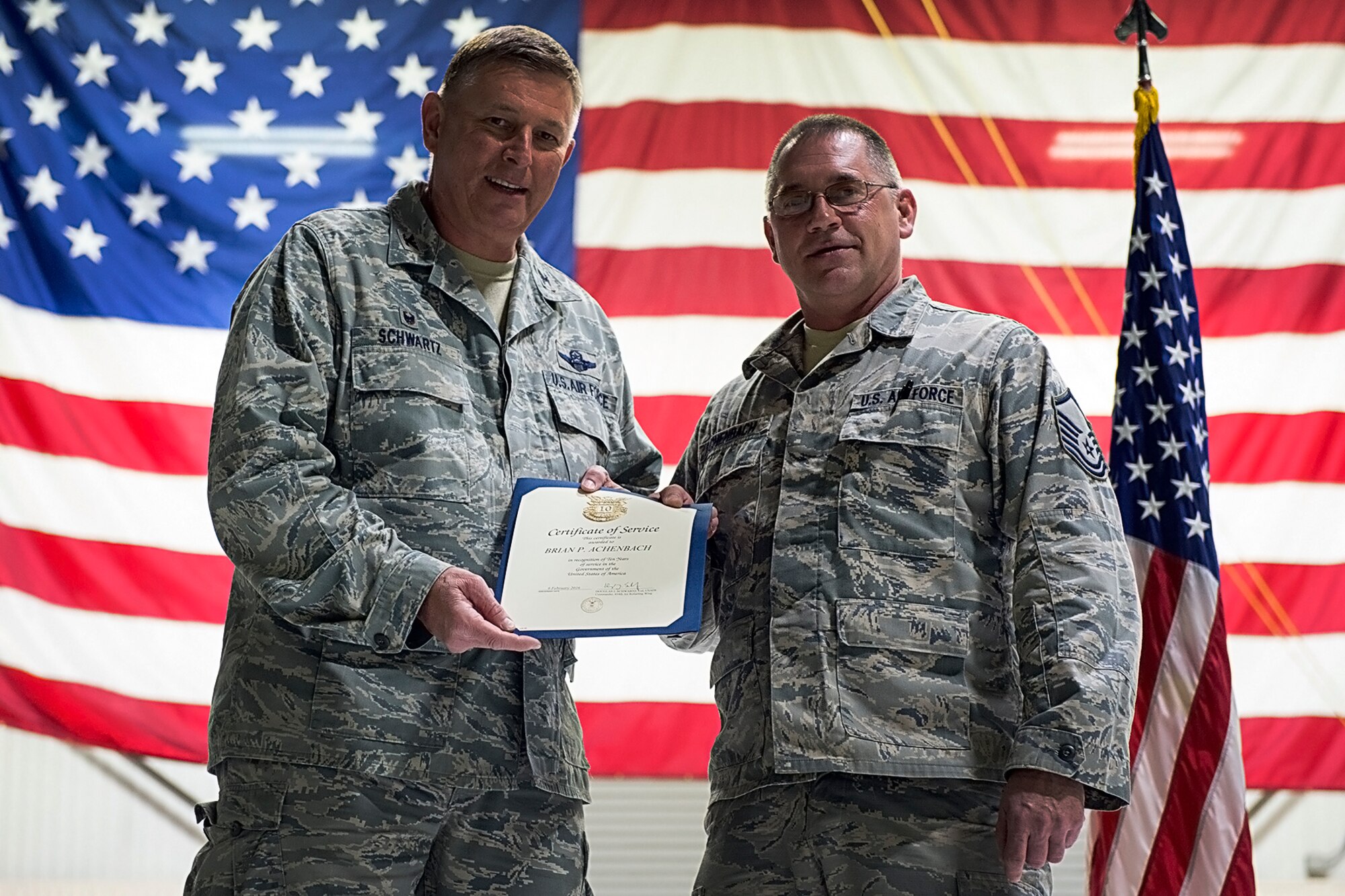 Master Sgt. Brian Achenback, A KC-135R Stratotanker crew chief with the 434th Maintenance Squadron, right, receives a certificate for 30 years of federal service March 9, 2016 at Grissom Air Reserve Base, Ind. Achenback and other civilians were recognized during a wing commander’s call. (U.S. Air Force photo/Douglas Hays)