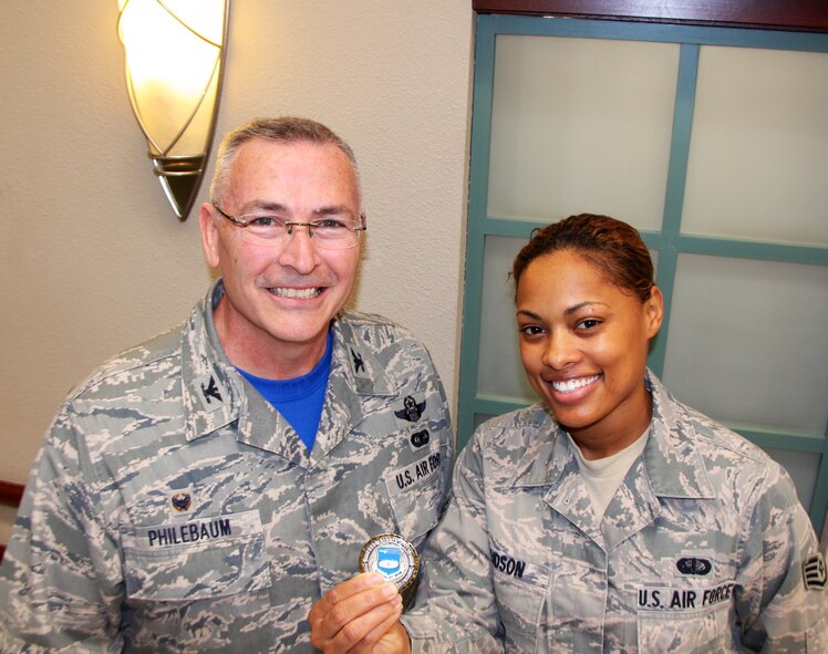 Col. Jonathan Philebaum, commander of the 932nd Airlift Wing, presented a special coin of achievement from the wing leader to Staff Sgt. Adonna Hudson at the dining facility.  She was recognized as the NCOIC of 932nd Food Services involved in preparing meals for both 932nd Airlift Wing and 126th Air National Guard members during the busy Unit Training Assembly weekend, which also included a visit from Lt. Gen. Samuel D. Cox, the commander of 18th Air Force.   She was surprised when the 932nd Airlift Wing commander pulled a coin out of his pocket for her.  I'm humbled by the experience and didn't expect it at all, but I'm glad that I was able to represent my unit and women in the military with pride during Women's National History Month, said Hudson.  (U.S. Air Force photo by Maj. Stan Paregien)