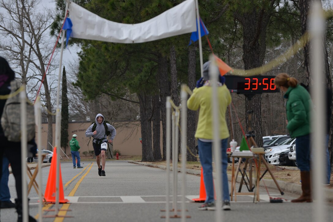 Peninsula Track Club members cheer-on 5K ruck march challenge participants at the finish line at Fort Eustis, Va., March 5, 2016. The track club monitored the finish line and collected the times of each runner. (U.S. Air Force photo by Staff Sgt. Natasha Stannard)