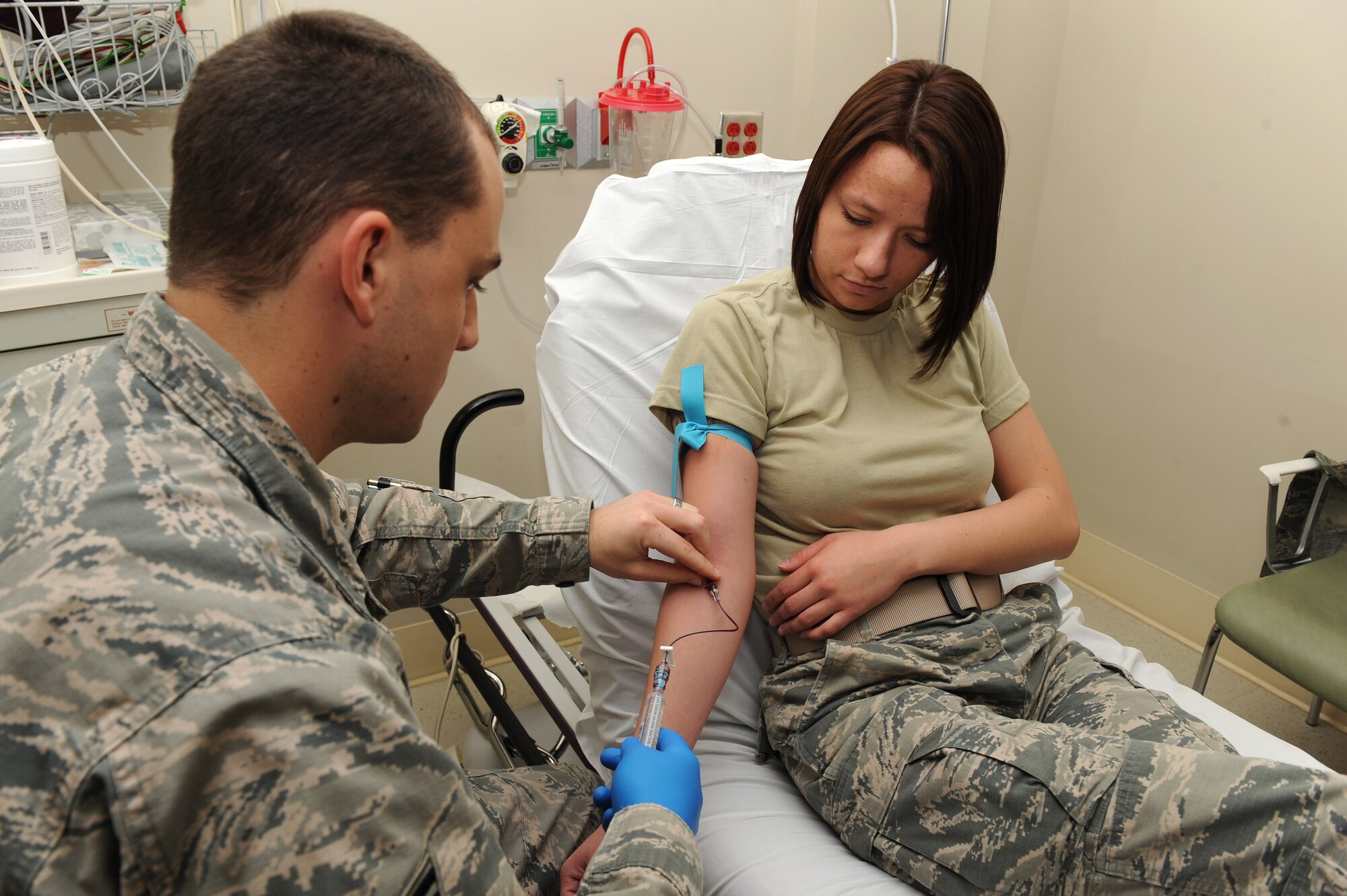 U.S. Air Force Staff Sgt. Christopher Leonard, paramedic assigned to the 633rd Medical Operations Squadron, demonstrates  on  Airman 1st Class Lindsey Schmalfeldt, an aerospace medical technician assigned to the 633rd MDOS, how to properly insert an Intravenous therapy at Langley Air Force Base, Va., March 7, 2016. The IVs are used for many things in the emergency room, ranging from rehydration, administering medication and drawing blood. (U.S. Air Force photo by Senior Airman Brittany E. N. Murphy)
