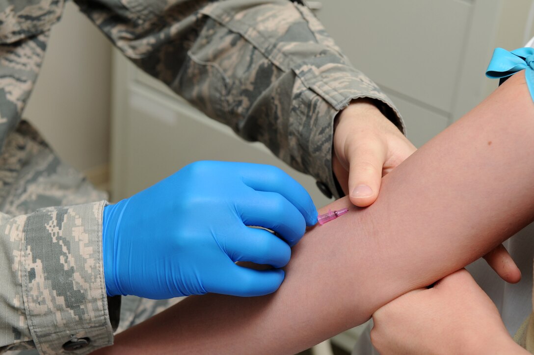 U.S. Air Force Staff Sgt. Christopher Leonard, a paramedic assigned to the 633rd Medical Operations Squadron, inserts a needle into the arm of Airman 1st Class Lindsey Schmalfeldt, an aerospace medical technician assigned to the 633rd MDOS, during training at Langley Air Force Base, Va., March 7, 2016. Properly inserting intravenous therapy is part of the foundation that aerospace medical trainees are expected to learn before they report to their next duty station. (U.S. Air Force photo by Senior Airman Brittany E. N. Murphy)
