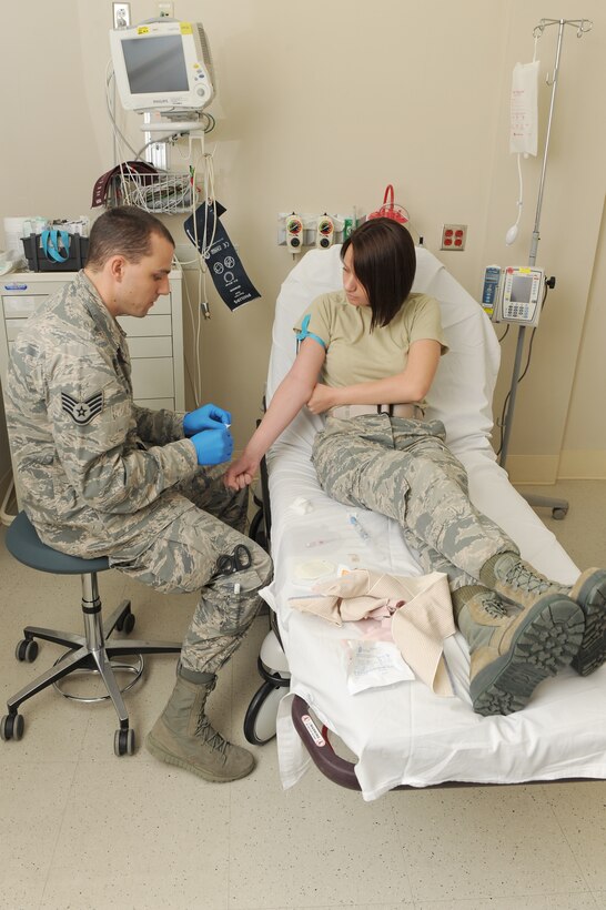 U.S. Air Force Staff Sgt. Christopher Leonard, a paramedic assigned to the 633rd Medical Operations Squadron, demonstrates how to give a patient IV therapy to Airman 1st Class Lindsey Schmalfeldt, an aerospace medical technician assigned to the 633rd MDOS, at Langley Air Force Base, Va., March 7, 2016. Technicians–in-training must obtain basic skills in their career field prior to reporting to their next duty station. (U.S. Air Force photo by Senior Airman Brittany E. N. Murphy)

