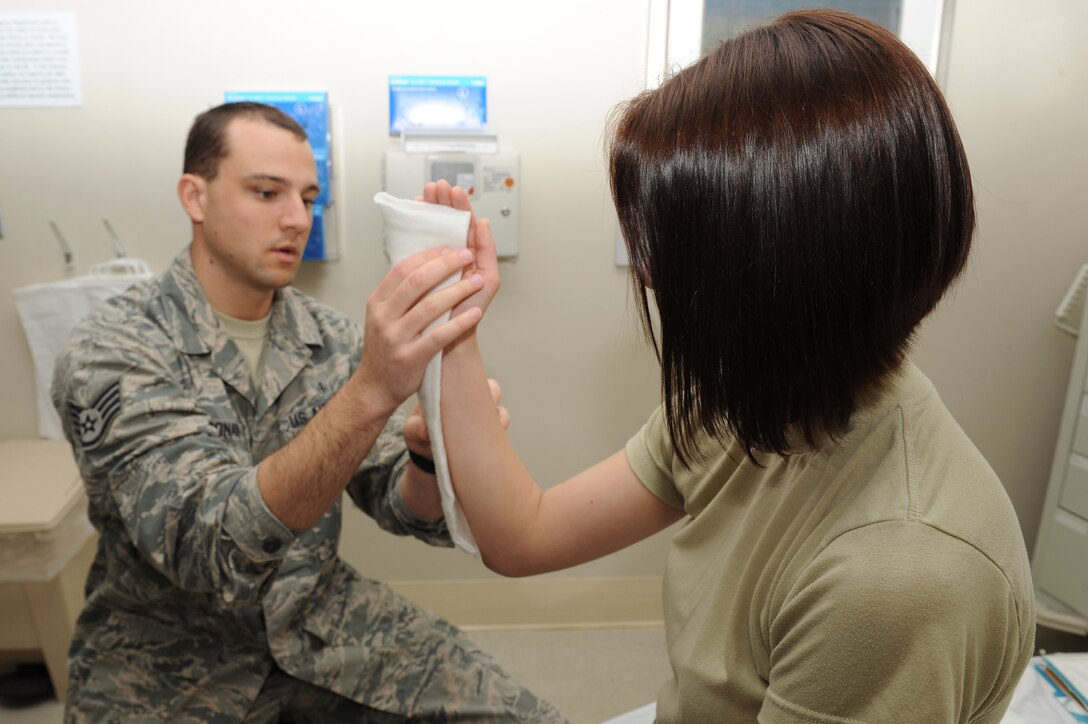U.S. Air Force Staff Sgt. Christopher Leonard, a paramedic assigned to the 633rd Medical Operations Squadron, forms Ortho-glass around the wrist of Airman 1st Class Lindsey Schmalfeldt, an aerospace medical technician assigned to the 633rd MDOS, while training her on how to properly apply a splint at Langley Air Force Base, Va., March 7, 2016. Medical technicians receive on-the-job training as a part of their phase two portion of technical school, prior to reporting to their next duty station. (U.S. Air Force photo by Senior Airman Brittany E. N. Murphy)