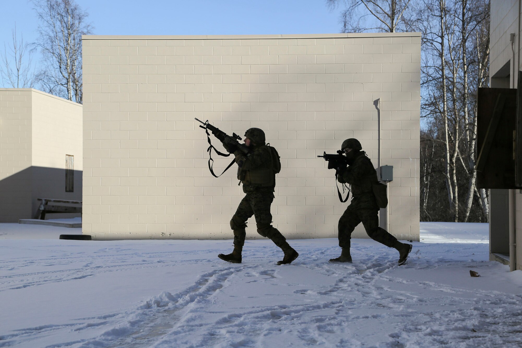 U.S. Marines assigned to Detachment Military Police Company D, 4th Law Enforcement Battalion, assault and clear a complex during military operations on urban terrain (MOUT) training at Joint Base Elmendorf-Richardson, Alaska, March 6, 2016. The MOUT training prepared the Marines for their upcoming deployment to Serbia where they will serve as military police advisors. (U.S. Air Force photo/Alejandro Pena)