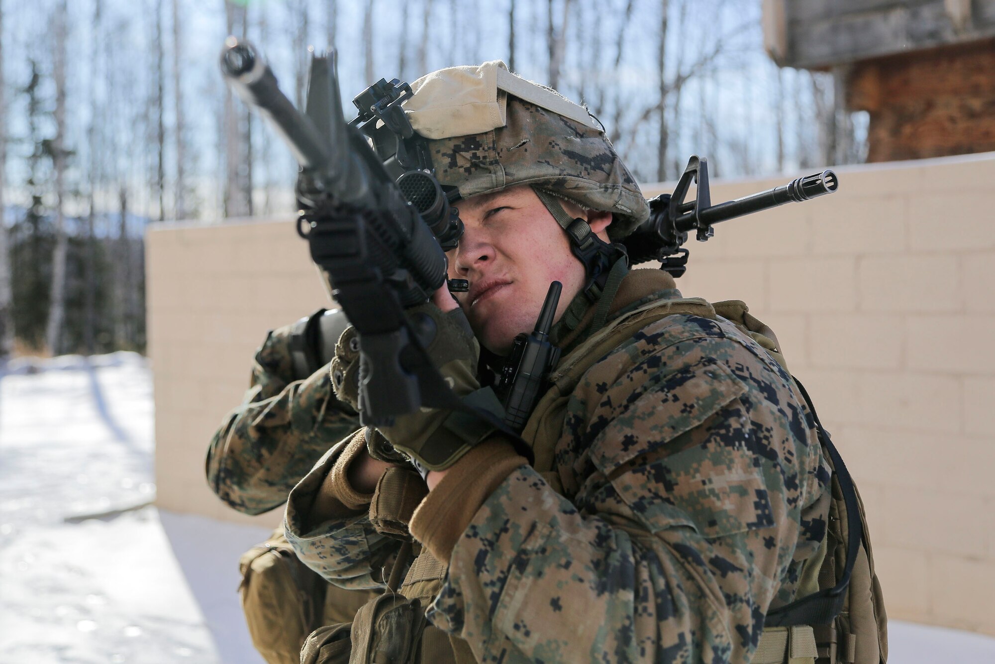 U.S. Marine Corps Cpl. Joseph Myers, assigned to Detachment Military Police Company D, 4th Law Enforcement Battalion, holds a security position while assaulting Baumeister City military operations on urban terrain (MOUT) complex at Joint Base Elmendorf-Richardson, Alaska, March 6, 2016. The MOUT training prepared the Marines for their upcoming deployment to Serbia where they will serve as military police advisors. (U.S. Air Force photo/Alejandro Pena)