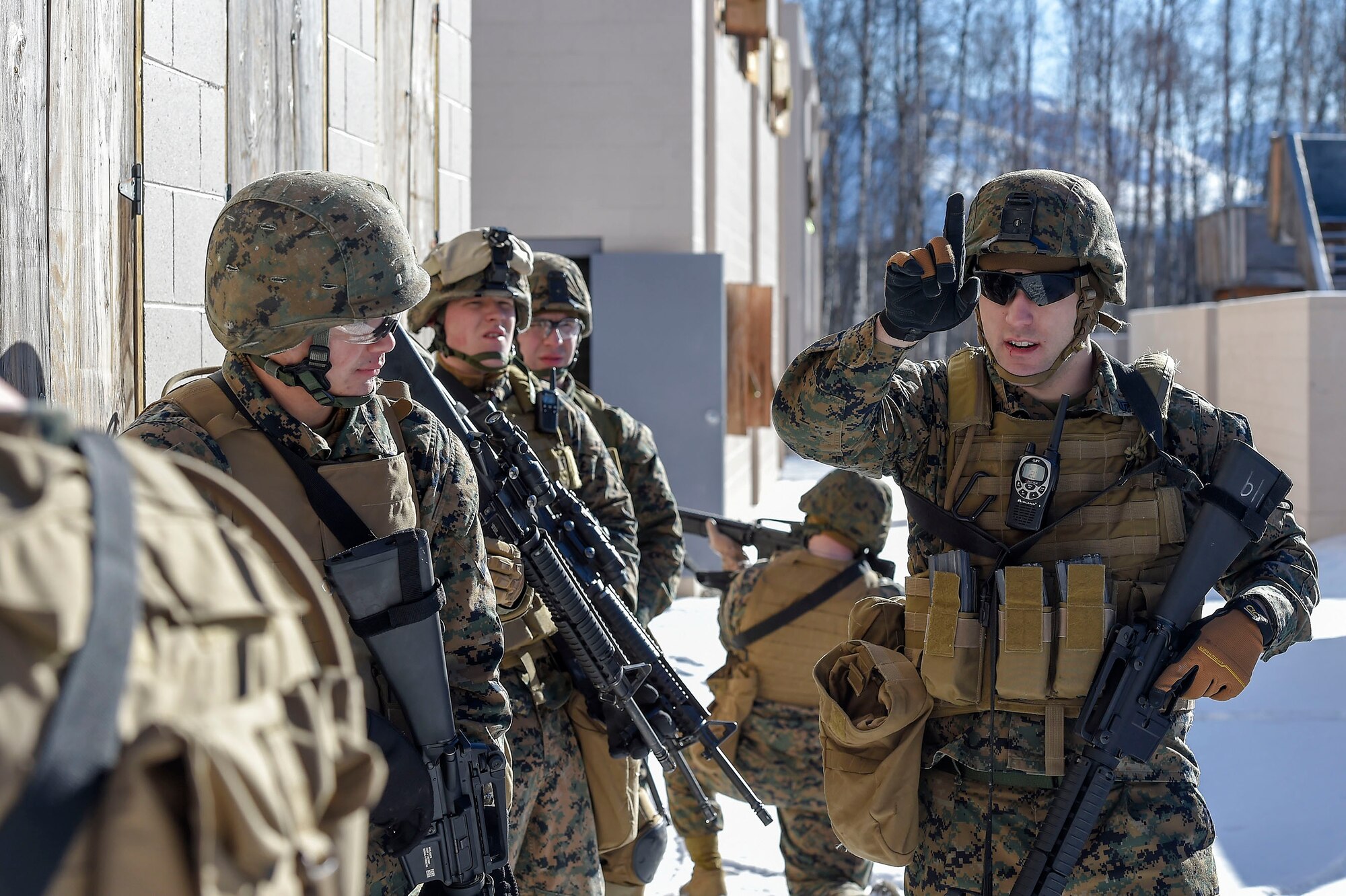 U.S. Marine Corps Cpl. William Worthy, right, assigned to Detachment Military Police Company D, 4th Law Enforcement Battalion, directs his squad while clearing a complex during military operations on urban terrain (MOUT) training at Joint Base Elmendorf-Richardson, Alaska, March 6, 2016. The MOUT training prepared the Marines for their upcoming deployment to Serbia where they will serve as military police advisors. (U.S. Air Force photo/Alejandro Pena)