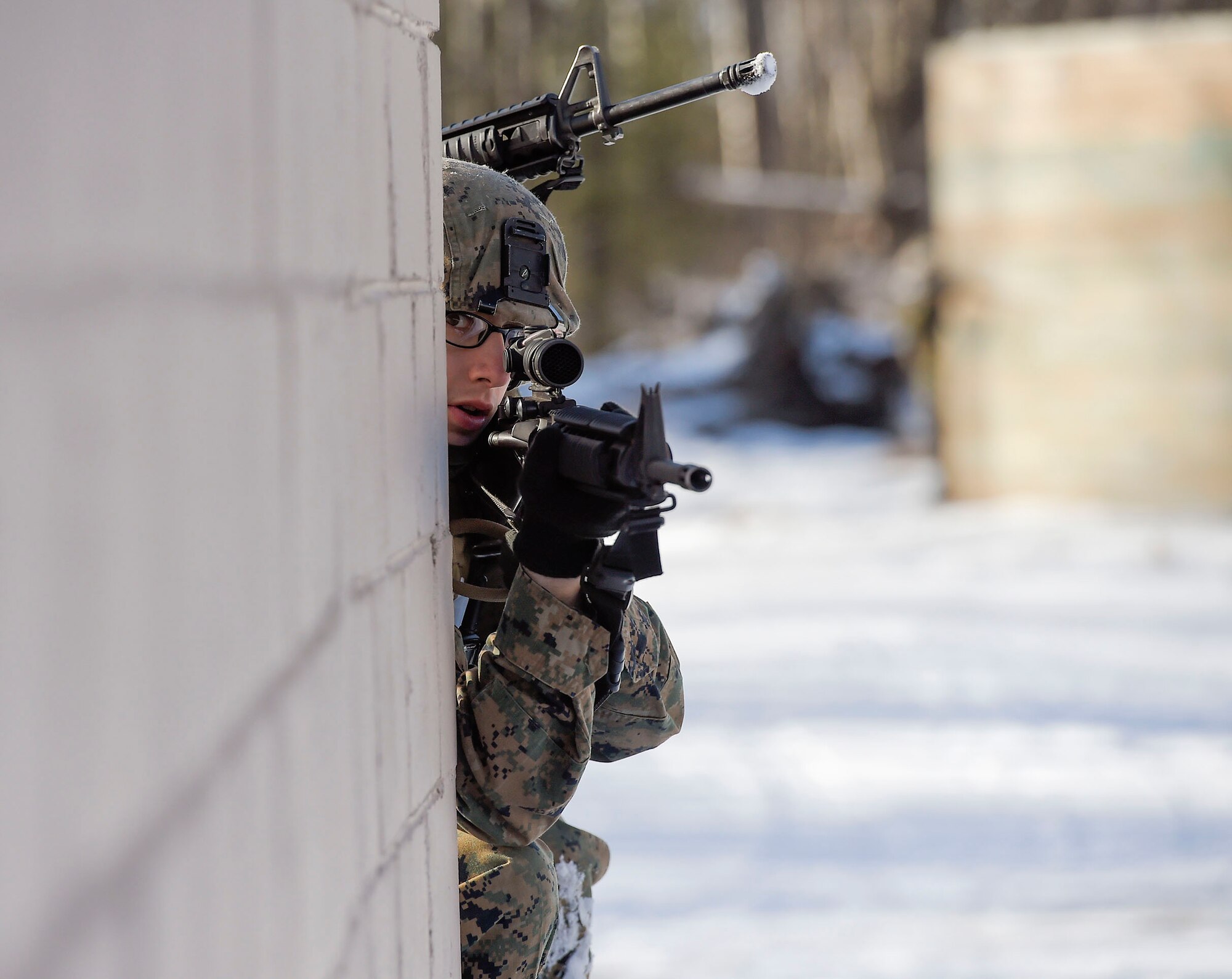 U.S. Marine Corps Lance Cpl. Nick Ruthruff, assigned to Detachment Military Police Company D, 4th Law Enforcement Battalion, holds a security position while assaulting Baumeister City military operations on urban terrain (MOUT) complex at Joint Base Elmendorf-Richardson, Alaska, March 6, 2016. The MOUT training prepared the Marines for their upcoming deployment to Serbia where they will serve as military police advisors. (U.S. Air Force photo/Alejandro Pena)