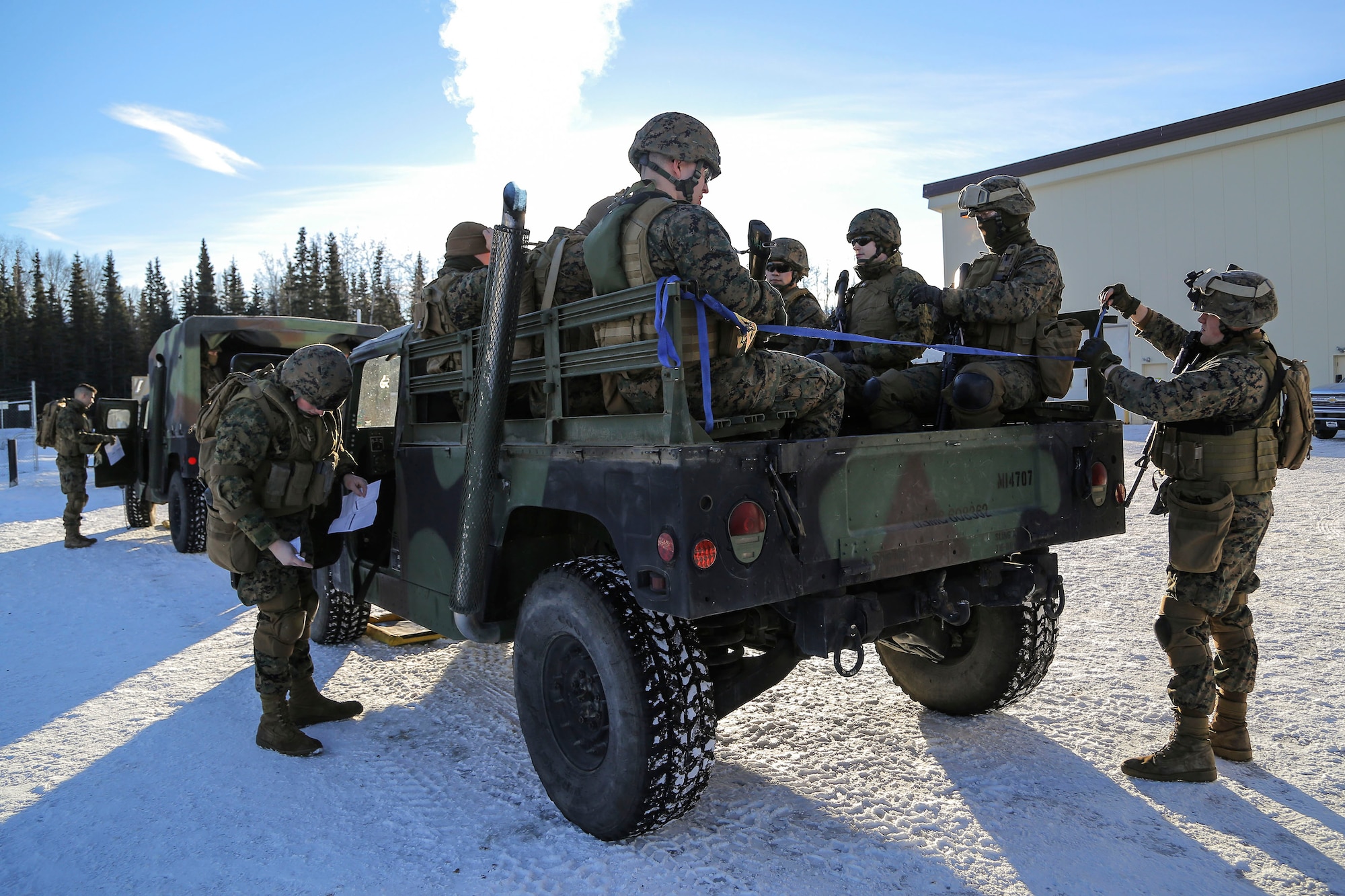 U.S. Marines assigned to Detachment Military Police Company D, 4th Law Enforcement Battalion, prepare to convoy to Baumeister City military operations on urban terrain (MOUT) complex at Joint Base Elmendorf-Richardson, Alaska, March 6, 2016. The MOUT training prepared the Marines for their upcoming deployment to Serbia where they will serve as military police advisors. (U.S. Air Force photo/Alejandro Pena)