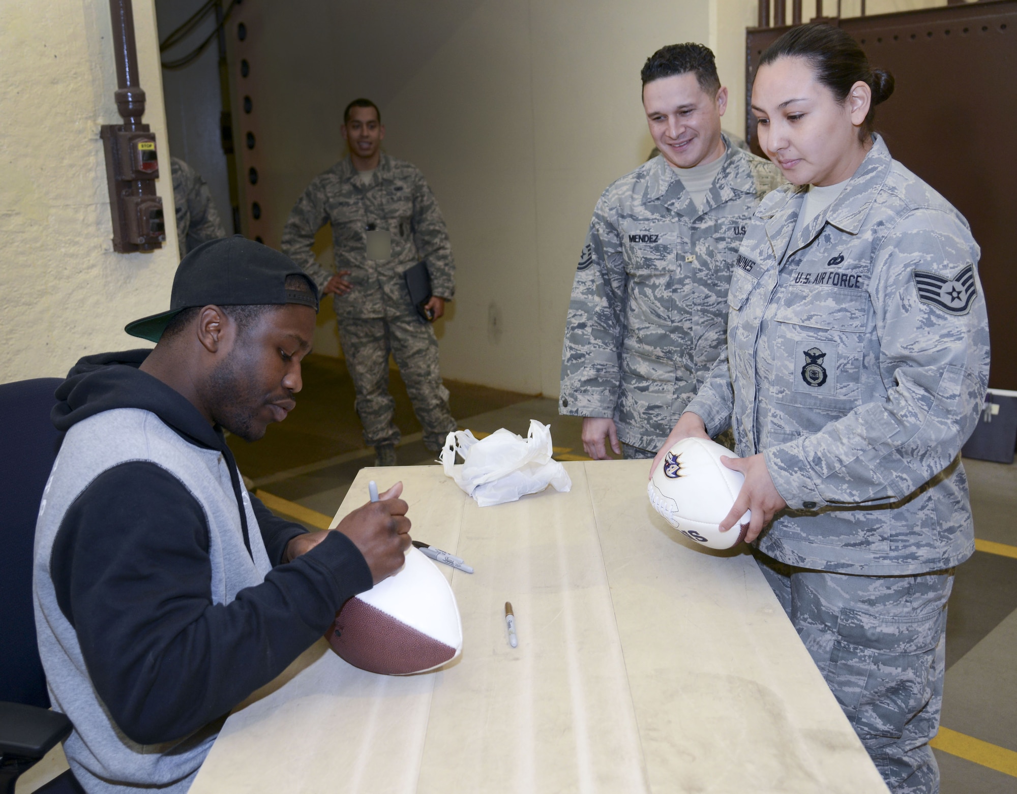 PETERSON AIR FORCE BASE, Colo. – National Football League Baltimore Ravens running back Justin Forsett signs an autograph for a Cheyenne Mountain Air Force Station Airman during a visit celebrating 50 years of CMAFS operations March 4, 2016. The visit and tour is part of the ongoing 50th Anniversary celebration for CMAFS. The installation was declared fully operational April 20, 1966. (U.S. Air Force photo by Tech. Sgt. Jared Marquis)