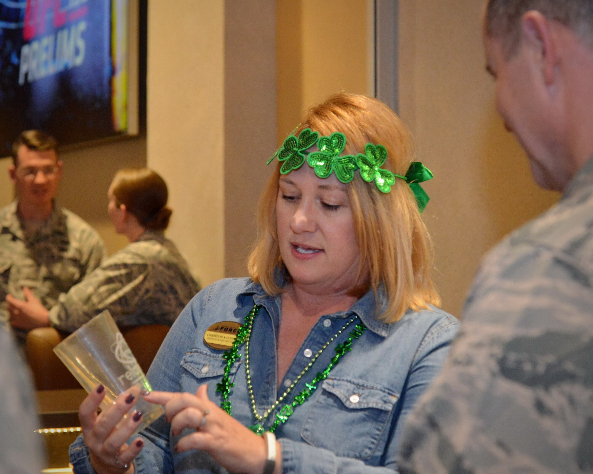 Christine Kaleikini, 377th Force Support Squadron operations officer, shows a Relativity Bar and Grille glass to 377th Air Base Wing Commander Col. Eric Froehlich. Relativity patrons will be able to buy a glass, have it engraved with their name at the Arts & Crafts Center and then store and use it at the bar. (Photo by Jamie Burnett)