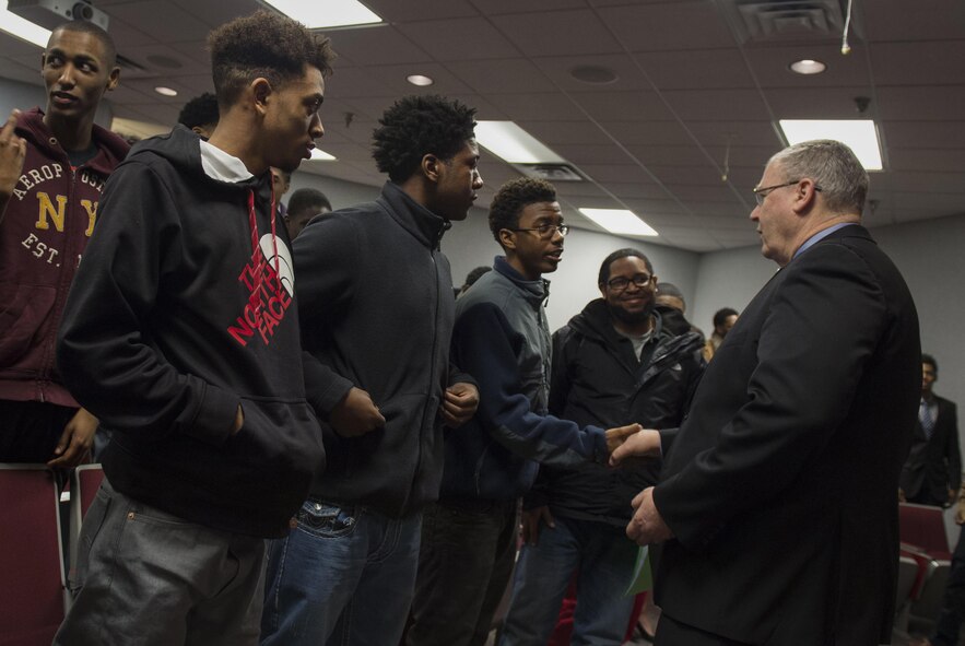 Deputy Defense Secretary Bob Work presents his challenge coin to students from the Dayton, Ohio, area after speaking to them about technology and the Defense Department as part of a 'Week at the Labs event at Wright-Patterson Air Force Base, Ohio, March 3, 2016. (DoD photo/Air Force Senior Master Sgt. Adrian Cadiz.)