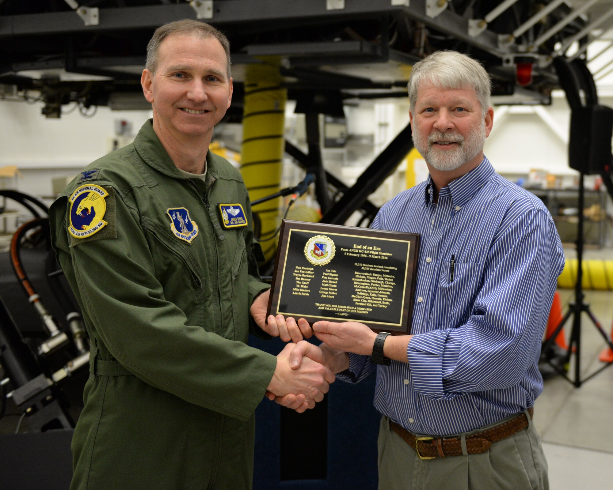 U.S. Air Force Colonel James Ryan, 157th Air Refueling Wing commander, New Hampshire Air National Guard, presents a plaque to Mr. Jon VanGuilder, regional site manager for Delaware Resource Group, during the retirement of the KC-135 flight simulator, Pease Air National Guard Base, New Hampshire, March, 9, 2016. DRG supports the daily operation of the simulator.  The simulator is being retired to make way for a new KC-46 weapons trainer slated to arrive in the spring of 2017. (U.S. Air National Guard photo by Staff Sgt. Curtis J. Lenz)