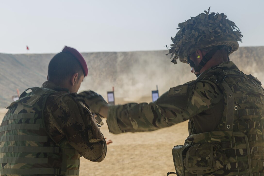 A British soldier assisting Task Group Taji helps an Iraqi soldier adjust his stance at Camp Taji, Iraq, Oct. 11, 2015. British soldiers assist Task Group Taji, training Iraqi soldiers of the 71st Iraqi army brigade as part of the build partner capacity sites of the Operation Inherent Resolve mission. The Iraqi soldiers were training with Task Group Taji to learn basic soldier skills in order to defeat the Islamic State of Iraq and the Levant. 