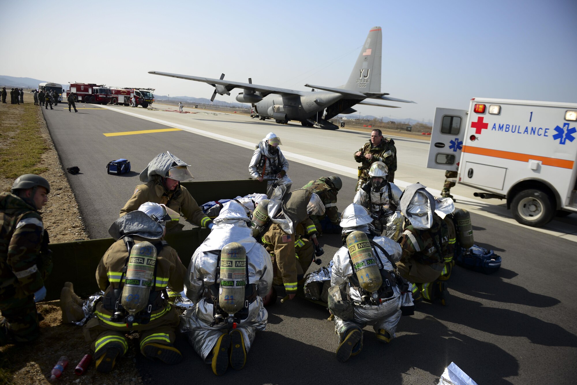 First responders from the 51st Fighter Wing provide assistance to mock wounded personnel during Exercise Beverly Midnight 16-01, March 9, 2016, at Osan Air Base, Republic of Korea. This particular exercise scenario involved a C-130H Hercules cargo aircraft assigned to the 374th Airlift Wing from Yokota Air Base, Japan, which took simulated small-arms fire from opposing forces upon landing. (U.S. Air Force photo by Staff Sgt. Jonathan Steffen/Released)
