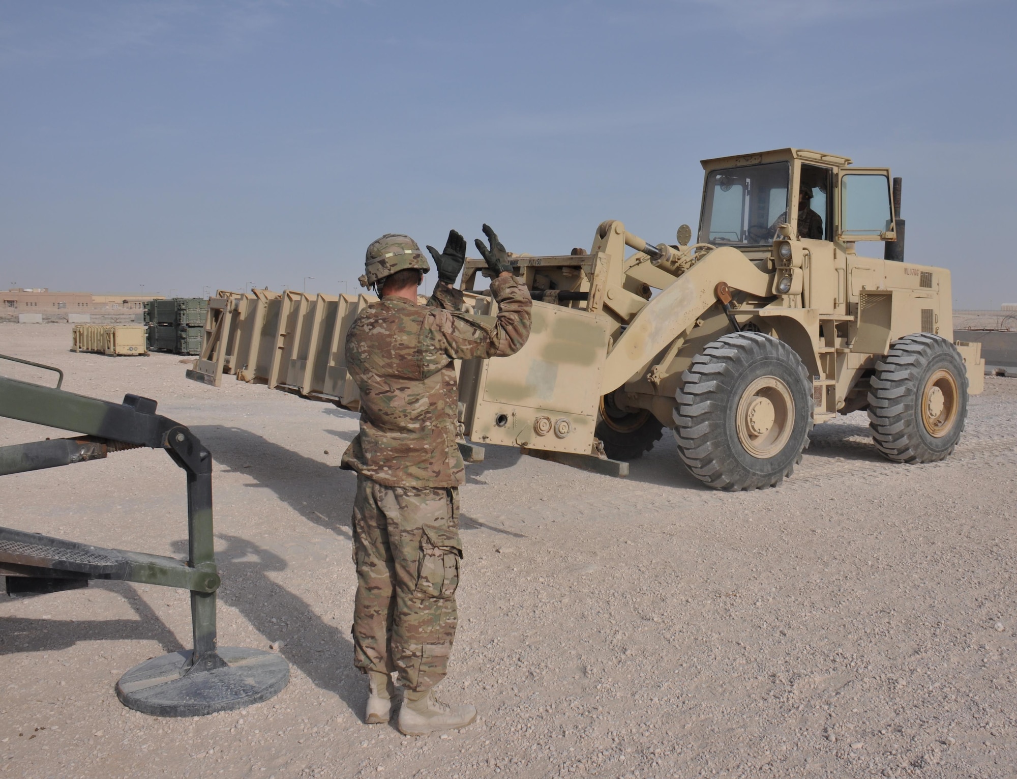 Spc. Peter Clark, 1-62 Delta Battery Air Defense Artillery Regiment Patriot station launcher operator and maintainer from Kittery, Maine, guides a forklift operated by Pfc. Brandon Long, 1-62 Delta Battery ADA Regiment Patriot station launcher operator and maintainer from Montgomery, Alabama, into position during a missile reloading training exercise at Al Udeid Air Base, Qatar Mar. 4. The Patriot missiles at AUAB protect the base from a variety of airborne threats including tactical ballistic missiles and drones.  (U.S. Air Force photo by Tech. Sgt. James Hodgman/Released)