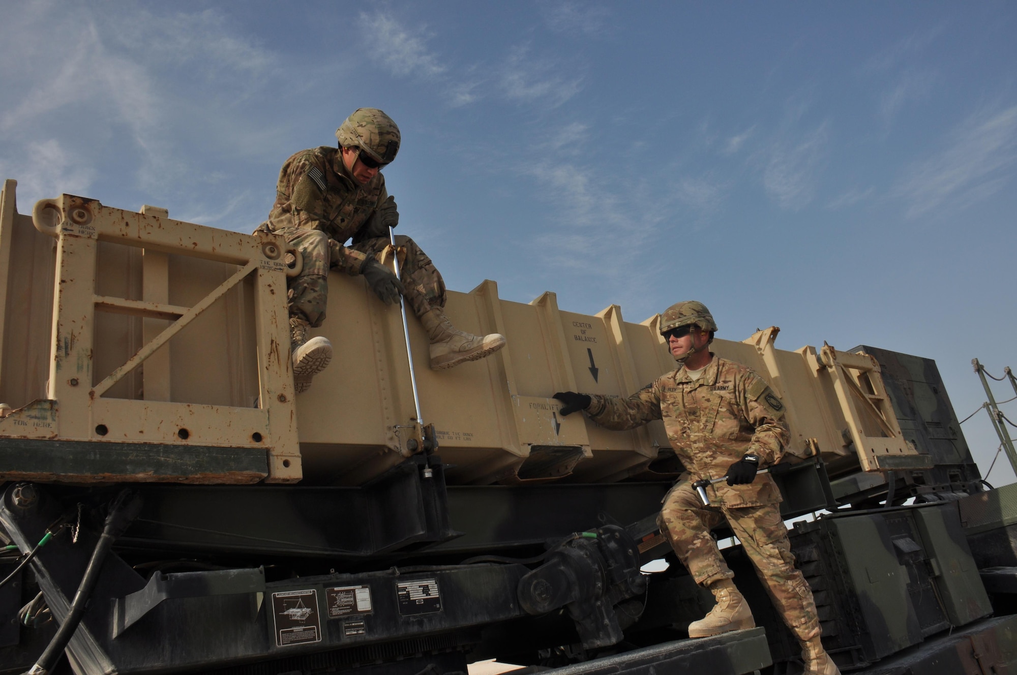 Pfc. Kelson Weber (Left), from Waukesha, Wisconsin and Sgt. Clinton Riley (Right) from Tupelo, Mississippi, both 1-62 Delta Battery Air Defense Artillery Regiment Patriot station launcher operators and maintainers, prepare a PAC-2 missile canister to be offloaded during a training exercise at Al Udeid Air Base, Qatar Mar. 4. The Patriot missiles at AUAB protect the base from a variety of airborne threats including tactical ballistic missiles and drones.  (U.S. Air Force photo by Tech. Sgt. James Hodgman/Released)