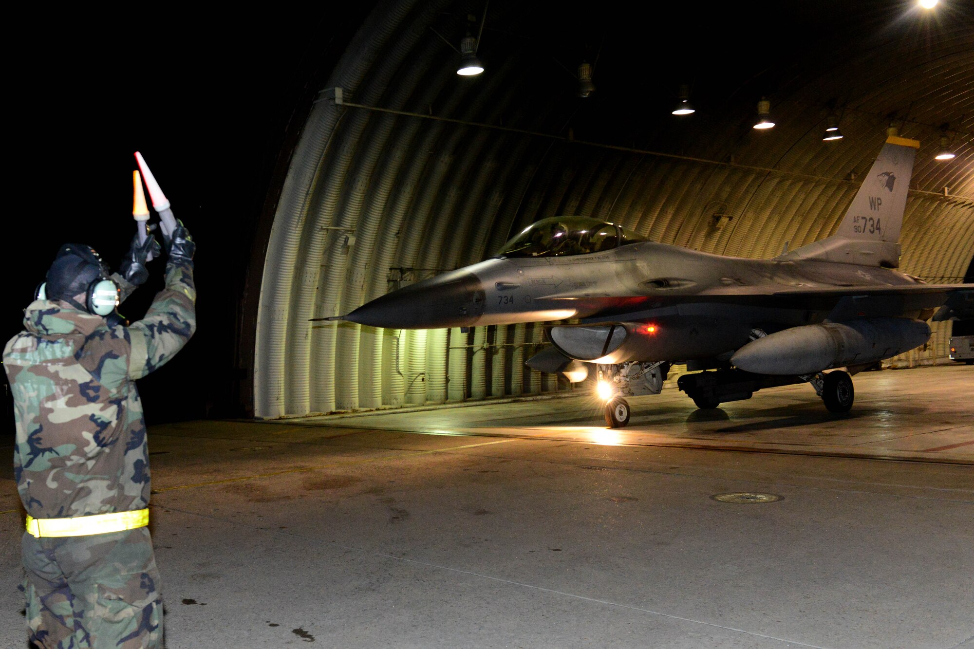 U.S. Air Force Senior Airman Matteo Pacini, 80th Fighter Squadron crew chief taxi’s out a jet during the Beverly Midnight 16-01 exercise Mar. 10, 2016. The high ops tempo combined with challenging exercise conditions ensured Wolf Pack Airmen are able to execute contingency operations while building confidence and unit cohesion. (U.S. Air Force photo by Senior Airman Ashley L. Gardner/ Released)
