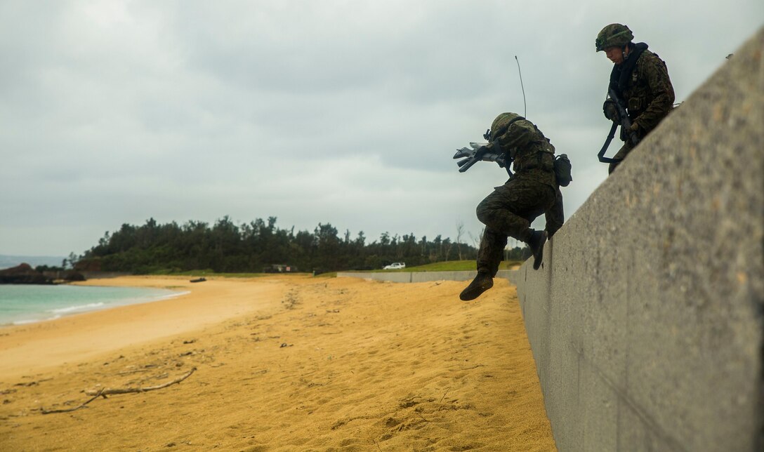 A member of the Japan Ground Self-Defense Force leaps over a seawall Mar. 9, at Kin Blue, Okinawa, Japan. The JGSDF members observed Marines from 3rd Reconnaissance Battalion, 3rd Marine Division, III Marine Expeditionary Force, conducting raid missions, amphibious training and scout swimmer classes. The JGSDF members are with the 43rd Infantry Regiment, 8th Division, Western Army. (U.S. Marine photo by Cpl. Tyler S. Giguere/Released)