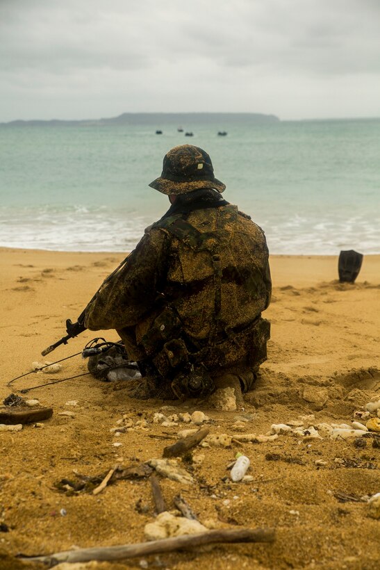 A member of the Japan Ground Self-Defense Force uses markers to guide an amphibious operation Mar. 9 at Kin Blue, Okinawa, Japan. The JGSDF members observed Marines with 3rd Reconnaissance Battalion, 3rd Marine Division, III Marine Expeditionary Force, conducting raid missions, amphibious training and scout swimmer classes. The JGSDF members are with the 43rd Infantry Regiment, 8th Division, Western Army. (U.S. Marine photo by Cpl. Tyler S. Giguere/Released)