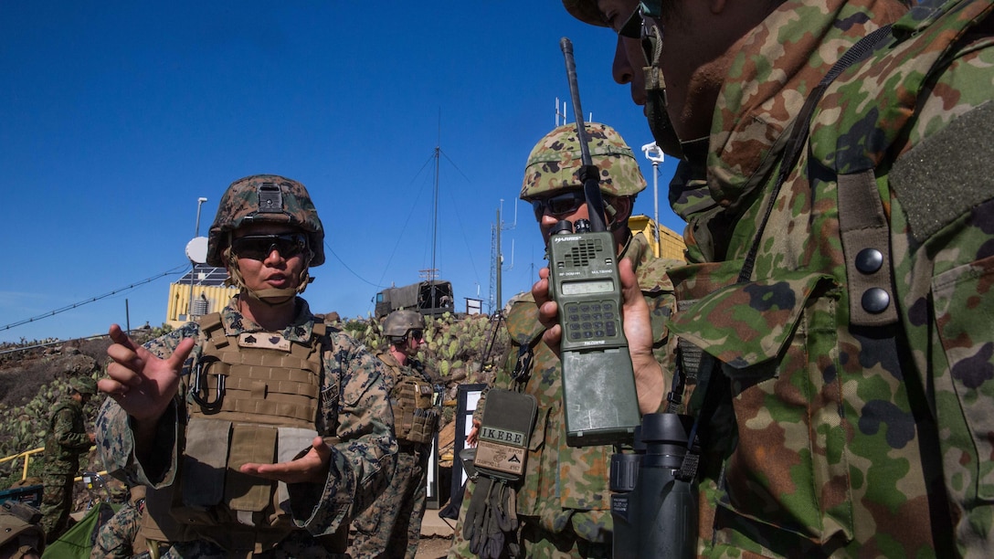 A U.S. Marine Corps interpreter attached to 1st Air Naval Gunfire Liaison Company translates radio messages for a soldier with Western Army Infantry Regiment, Japan Ground Self-Defense Force, during a supporting arms coordination center exercise on San Clemente Island, California, Feb. 22, 2016, as part of Exercise Iron Fist 2016. SACCEX  serves as a cooperative learning tool for the US-Japan partnership through the operation of a SACC, which has developed the USMC and JGSDF’s ability to integrate naval gunfire, mortars and close-air support  as a combined force.