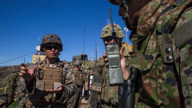 A U.S. Marine Corps interpreter attached to 1st Air Naval Gunfire Liaison Company translates radio messages for a soldier with Western Army Infantry Regiment, Japan Ground Self-Defense Force, during a supporting arms coordination center exercise on San Clemente Island, California, Feb. 22, 2016, as part of Exercise Iron Fist 2016. SACCEX  serves as a cooperative learning tool for the US-Japan partnership through the operation of a SACC, which has developed the USMC and JGSDF’s ability to integrate naval gunfire, mortars and close-air support  as a combined force.