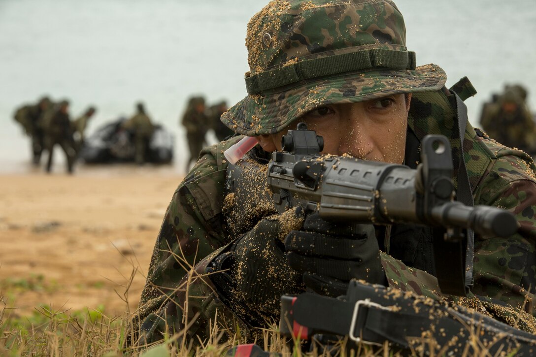 A member of the Japan Ground Self-Defense Force provides security during a beach landing Mar. 9 at Kin Blue, Okinawa, Japan. The JGSDF members observed Marines from 3rd Reconnaissance Battalion, 3rd Marine Division, III Marine Expeditionary Force, conducting raid missions, amphibious training and scout swimmer classes. The JGSDF members are with the 43rd Infantry Regiment, 8th Division, Western Army. (U.S. Marine Corps photo by Cpl. Tyler Ngiraswei/Released)