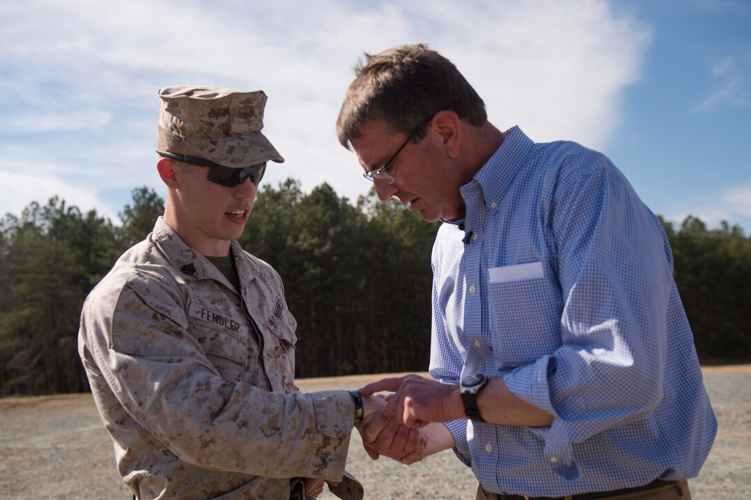 Defense Secretary Ash Carter looks at a Marine's Killed in Action bracelet on Marine Corps Base Quantico, Va., March 9, 2016. Secretary Carter visited the base to observe Marine Corps training and speak with Marines. DoD photo by Air Force Senior Master Sgt. Adrian Cadiz