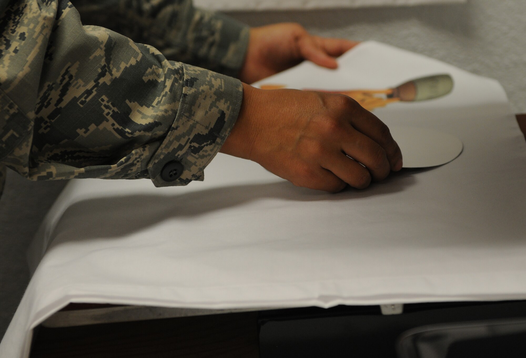 Tech. Sgt. Sally Stevenson, Airman and Family Readiness Center readiness NCO, adjust photos on a pillow case Feb. 29, 2016, Keesler Air Force Base, Miss. The pillow case program is one of several services available to families with deployed members, and allows children to receive pillow cases with photos of their deployed parent as a way to stay connected during the time apart. (U.S. Air Force photo by Senior Airman Holly Mansfield)
