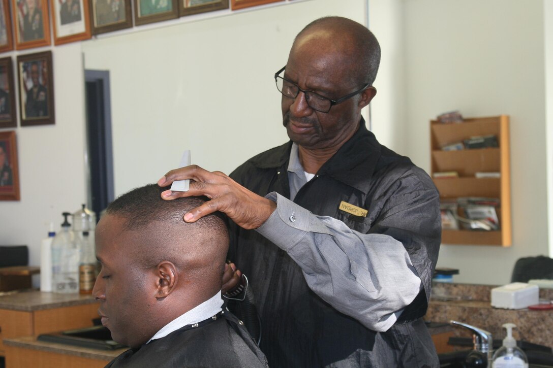 William Jordan, barber at the Marine Mart aboard Marine Corps Base Quantico, gives Capt. Travis Perkins a haircut Feb. 29. Jordan will retire March 24 after 55 years on the job.