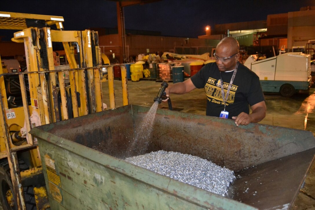 Charles Miller, a Fleet Readiness Center Southeast material identifier, washes a bin of aluminum scraps collected through the manufacturing process. Washing the scraps removes oil residue and dust so the metal can be taken to Defense Logistics Agency Disposition Services for resale. The recycling of metal scraps is one small part of the facility's drive towards decreasing its environmental footprint. Because of such efforts, FRCSE was awarded the CNO's Environmental Award for Sustainability. (U.S. Navy Photo by Clifford Davis/Released)
