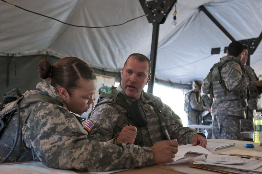 Staff Sgt. Carlos Diaz and Spc. Charlene Suliz, construction engineers with the 475th Engineer Company (Horizontal), an Army Reserve unit from Puerto Rico, review the day's plans March 8, 2016 during Combat Sustainment Support Exercise 78-16-01 at Fort Hunter-Liggett, Calif. (U.S. Army photo by Sgt. Christopher Bigelow/Released)