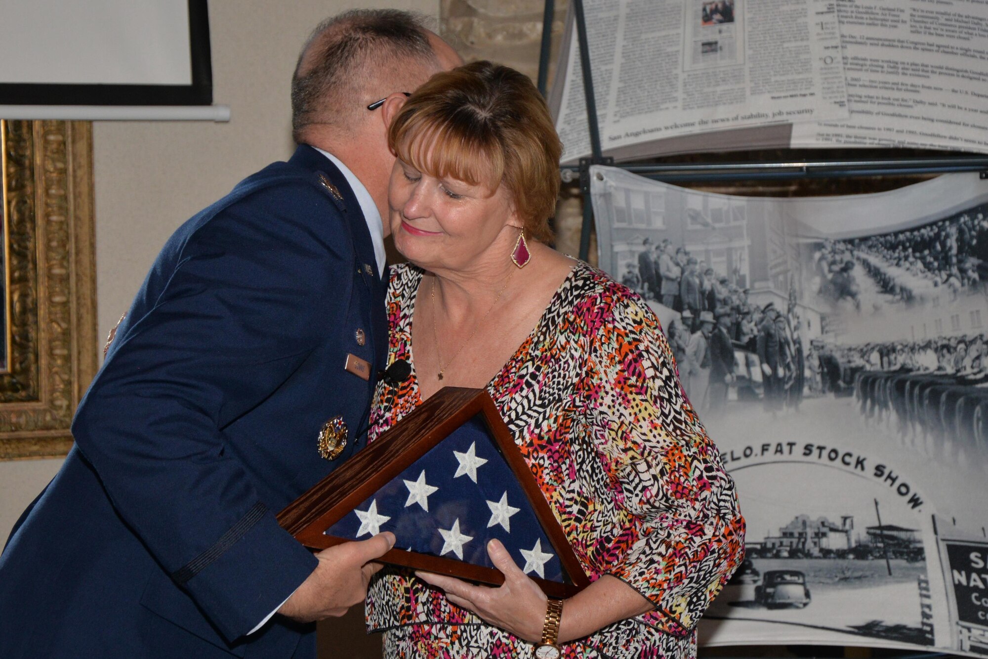 U.S. Air Force Col. Michael L. Downs, 17th Training Wing Commander, gives a flag to Susan M. Neighbors, wife of the late Phil Neighbors, during the Chamber of Commerce luncheon at the Bentwood Country Club in San Angelo, Texas, March 9, 2016. The flag was flown at half-staff over Goodfellow Air Force Base to commemorate the passing of Phil Neighbors. (U.S. Air Force photo by Airman 1st Class Randall A. S. Moose/Released)