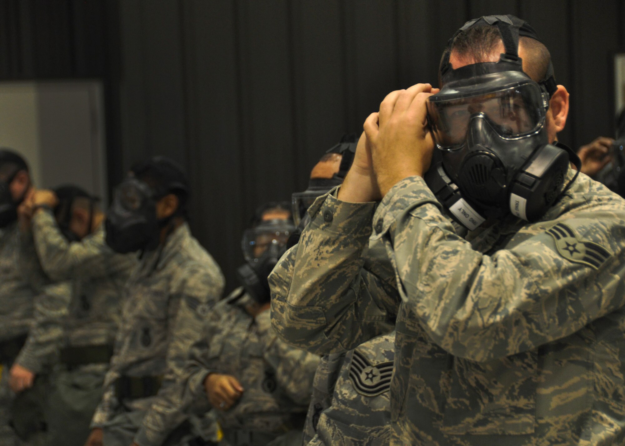 An airman puts on his gas mask at Dobbins Air Reserve Base, Ga, March 5, 2016. The airman was participating in a mock Mission Oriented Protective Posture level exercise during a predeployment training held by Air Force Reserve Command. (U.S. Air Force Photo by Senior Airman Miles Wilson)