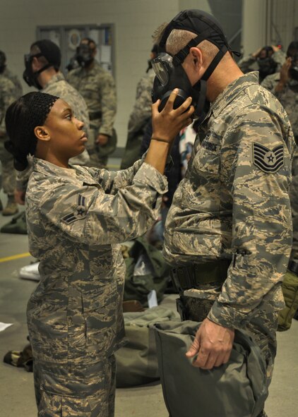 An Airman has his wingman help him check his gas mask at Dobbins Air Reserve Base, Ga, March 5, 2016. They were participating in predeployment training and were practicing good teamwork, which was stressed during the training. (U.S. Air Force Photo by Senior Airman Miles Wilson)