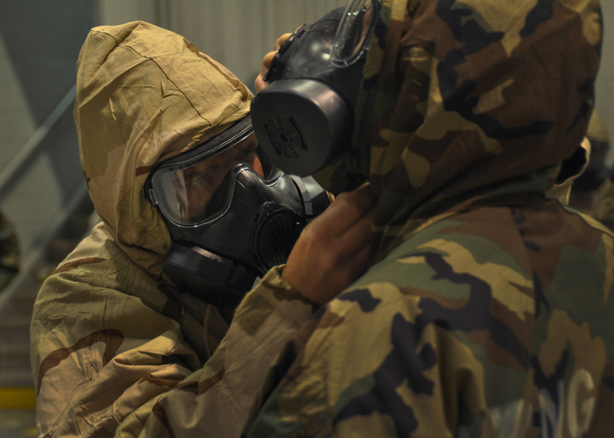 An airman checks his wingman's gas mask for any deficiencies at Dobbins Air Reserve Base, Ga, March 5, 2016. The Airmen were completing an exercise during a predeployment training that was held by Air Force Reserve Command. (U.S. Air Force Photo by Senior Airman Miles Wilson)