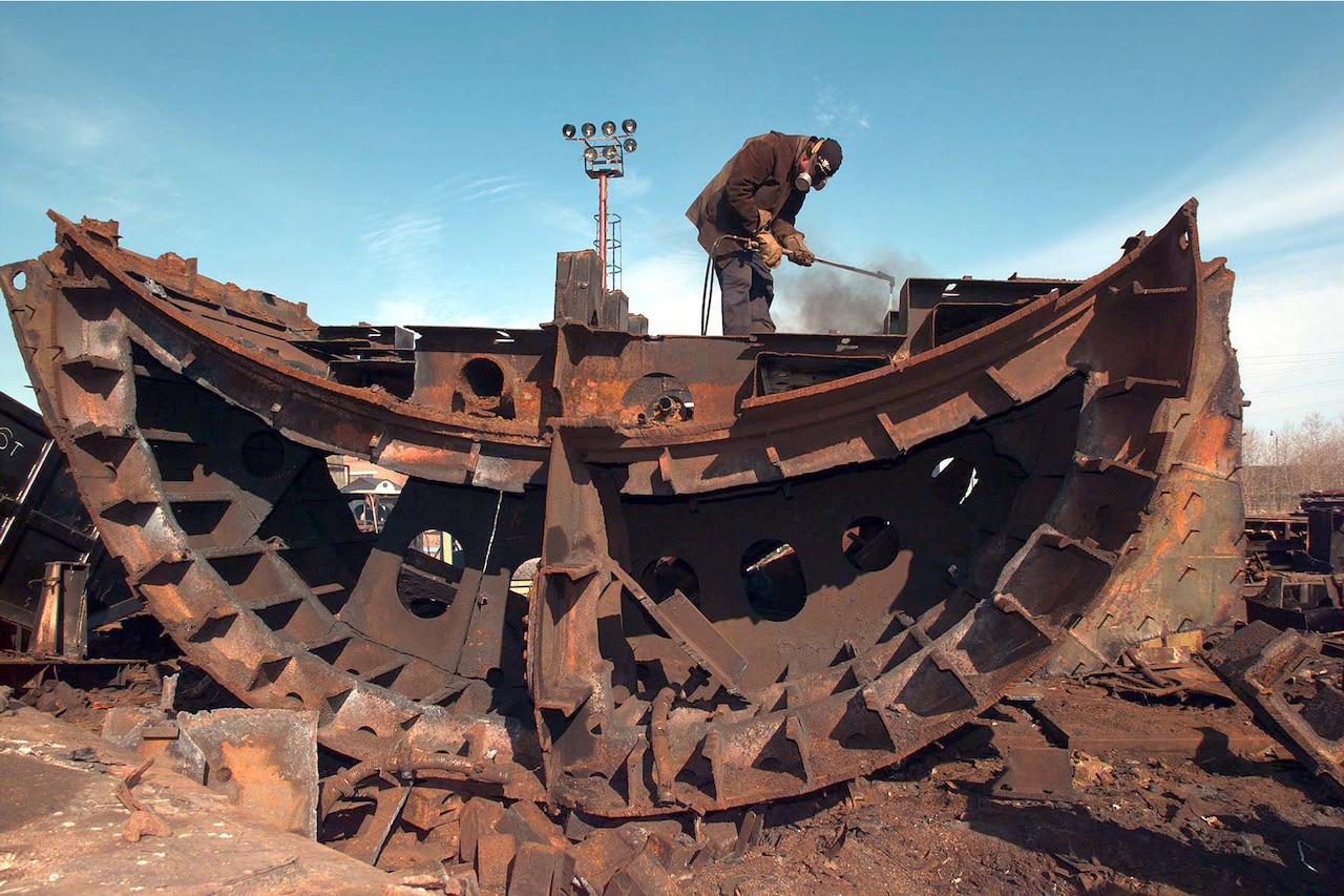 A Russian shipyard worker uses a cutting torch to breakdown a large bulge section of a Russian Oscar Class submarine at the Little Star shipyard in Severodvinsk, Russia, May 29, 1996.  Russian ballistic submarines are being dismantled as part of the Nunn-Lugar/Cooperative Threat Reduction Program.  DoD photo by Navy Petty Officer 1st Class Todd P. Cichonowicz
