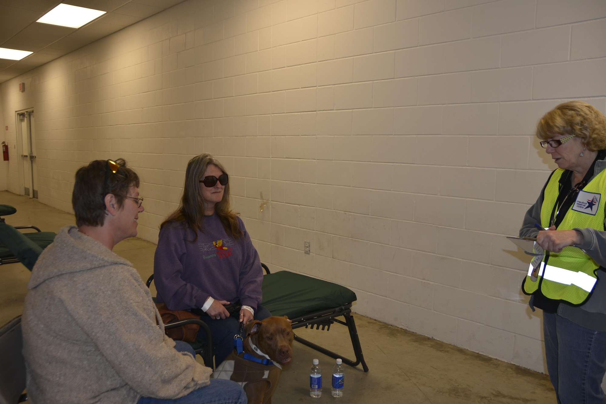 During an animal-related  disaster-response workshop at the Bay County Fairgrounds Feb. 28, a Medical Reserve Corp representative (right) talks with  a resident who came to the workshop shelter with her “seeing-eye dog.” The workshop event brought together a wide variety of emergency response agencies and focused on practicing providing disaster response assistance not only to people, but also their pets, to include service animals. 