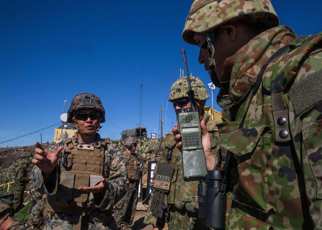 A U.S. Marine Corps interpreter attached to 1st Air Naval Gunfire Liaison Company translates radio messages for a soldier with Western Army Infantry Regiment, Japan Ground Self-Defense Force, during a supporting arms coordination center exercise, (SACCEX), on San Clemente Island, Feb. 22, 2016, as part of Exercise Iron Fist 2016. SACCEX  serves as a cooperative learning tool for the US-Japan partnership through the operation of a SACC, which has developed the USMC and JGSDF’s ability to intergrate naval gunfire, mortars and close-air support  as a combined force. (U.S. Marine Corps photo by Lance Cpl. Devan K. Gowans)