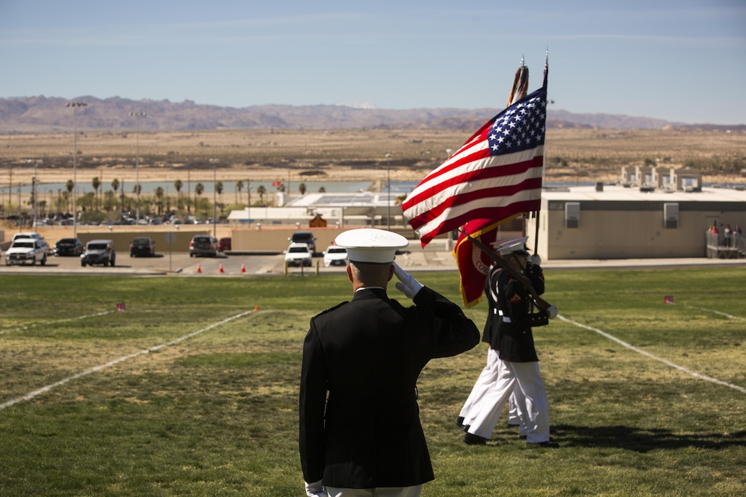 Maj. Gen. Lewis A. Craparotta, commanding general, Combat Center, salutes the national and Marine Corps colors carried by the Official Marine Corps Color Guard during a Battle Colors Ceremony at Lance Cpl. Torrey L. Gray Field March 9, 2016. (Official Marine Corps photo by Lance Cpl. Levi Schultz/Released)