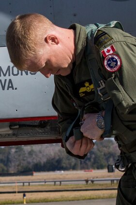 A pilot adjusts his flight gear on the flight line aboard Marine Corps Air Station Beaufort March 7. Marine Fighter Attack Squadron 122 departed for the Western Pa¬cific March 7 as part of the Unit Deployment Program. The squadron will sup¬port 6 multinational ex¬ercises, which will not only increase the readi¬ness of the Marines but safeguard international goodwill and ensure we can work with our allies effectively. The pilot is with VMFA-122.