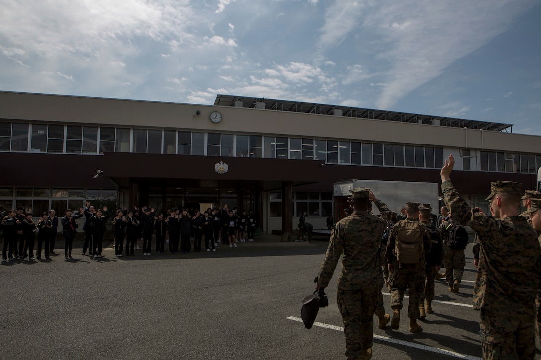 U.S. Marines with the III Marine Expeditionary Force Band wave farewell after singing the Marine's Hymn to students at Shichijo Junior High School, Kumamoto, Japan, Mar. 6. The Japan Ground Self-Defense Force Western Army Band and III MEF Band performed with and coached the students during their visit.The Marines were in Kumamoto to participate in the Western Army Band Music Festival, which celebrates the 60th Anniversary of the Western Army Band.