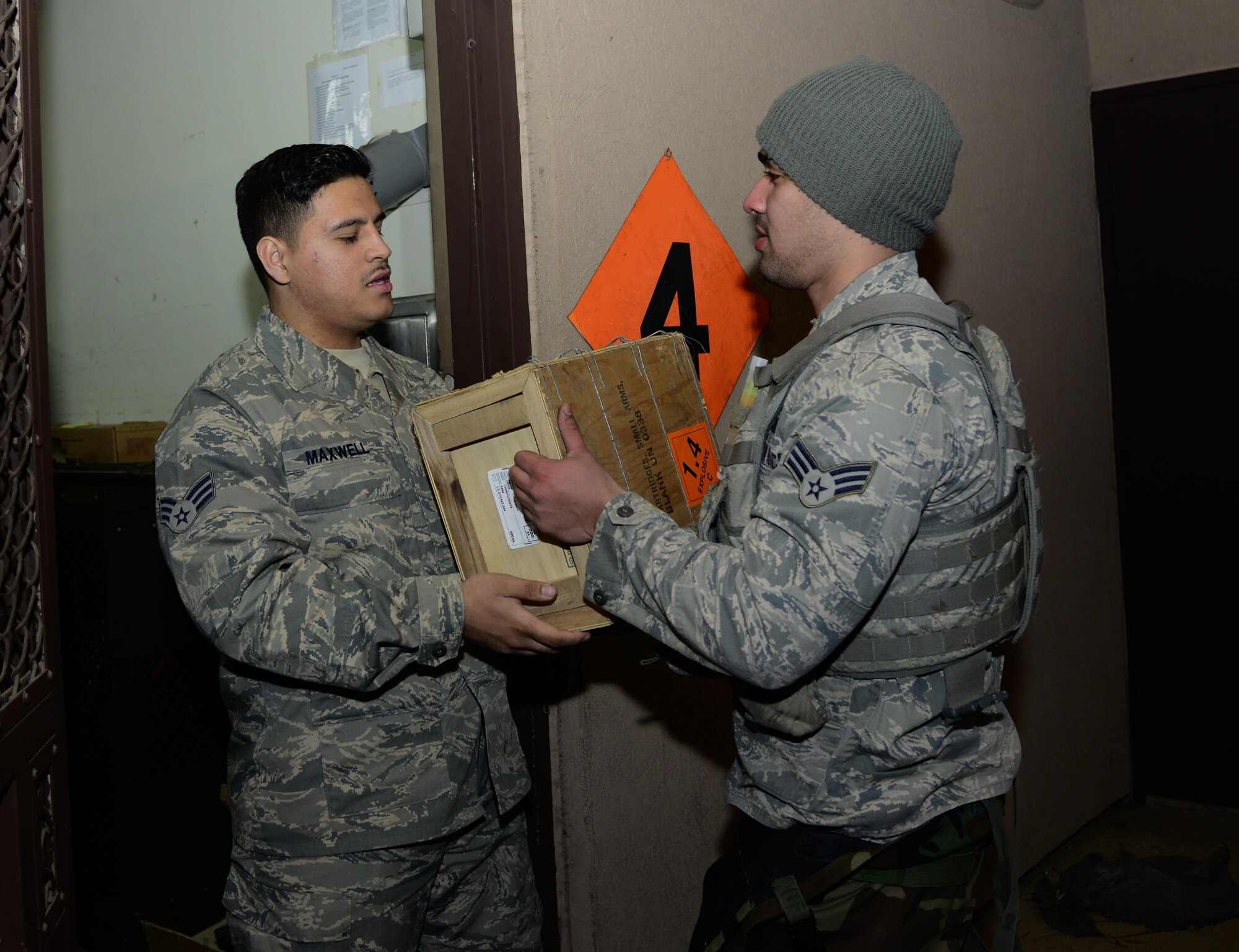 Senior Airman Sidney Maxwell, 51st Security Forces Squadron armorer, receives 50-caliber rounds from Senior Airman GianFranco Pagan Marquez, 51st SFS defender on Osan Air Base, Republic of Korea, March 10, 2016. Members working in the armory are accountable for every weapon and piece of ammunition issued to security forces Airmen. (U.S. Air Force photo by Senior Airman Kristin High/Released)
